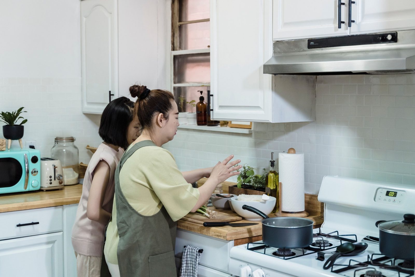 Eine Mutter und ihre Tochter kochen gemeinsam in der Küche.